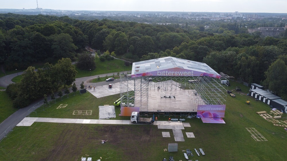 Scena plenerowa z daszkiem bittersweet montowana na trawiastym placu w parku