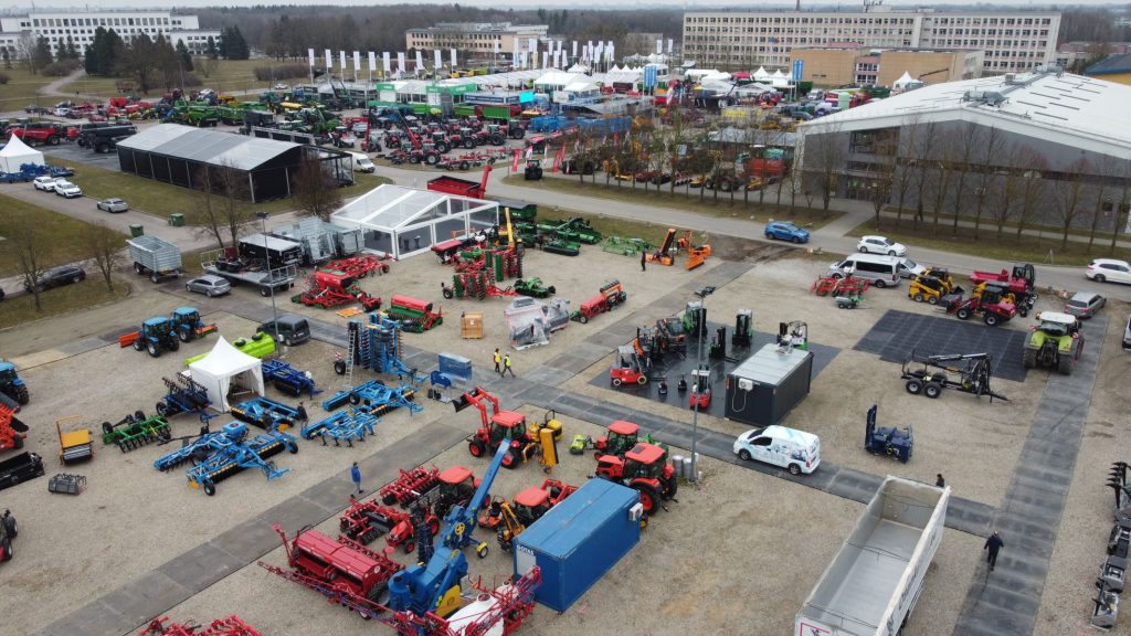 Widok z góry na targi rolnicze z różnorodnymi maszynami, namiotami i stoiskami wystawowymi.